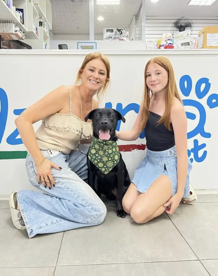 Família com cão preto de bandana verde na Azzurra na Pompeia