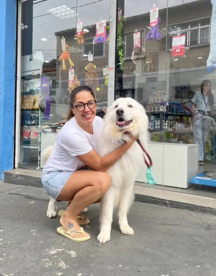 Tutora com cão branco grande na fachada da Azzurra na Pompeia