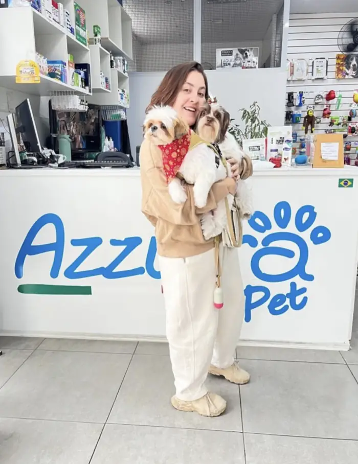 Tutora com dois shih tzus no colo na Azzurra Pet Shop