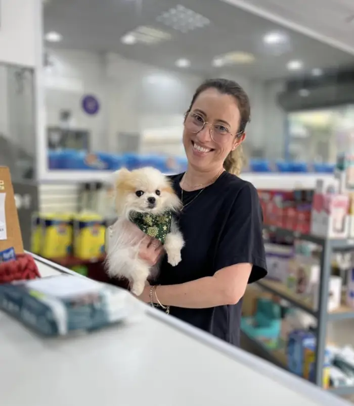 Tutora com lulu da Pomerânia filhote no balcão da Azzurra