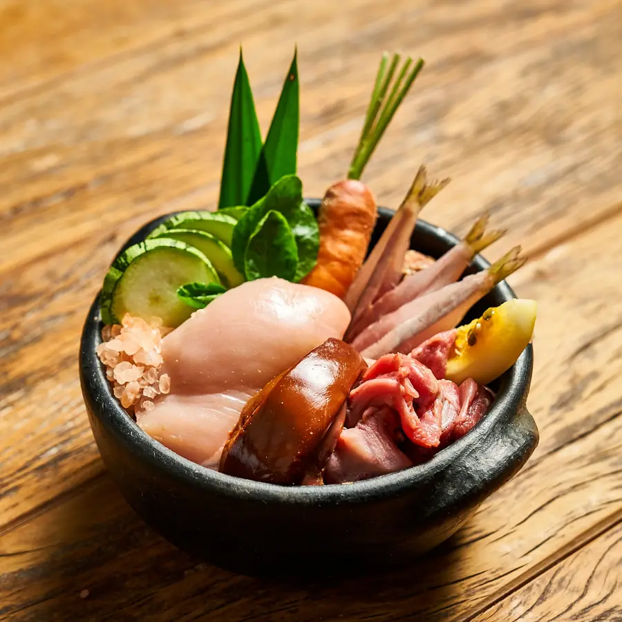 Tigela com ingredientes frescos da comida natural Raw Raw: frango, sardinha, moela, cenoura e pepino